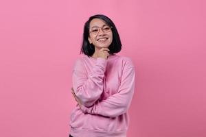 hermosa chica asiática sonriendo ampliamente en chaqueta rosa foto