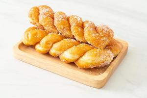 Sugar doughnut in spiral shape on wooden plate photo