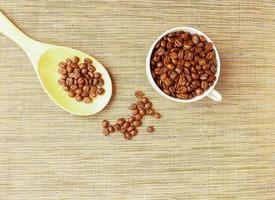Coffee beans roasted   in white cup with and wooden spoon photo