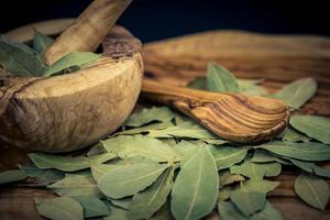 Bay leaves and juniper berries on olive wood photo