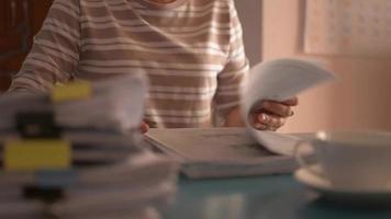 Woman working with document on the desk at home. video