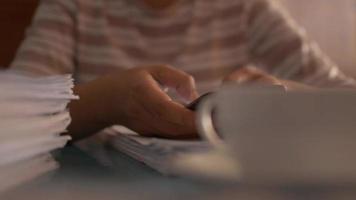 mujer con smartphone en la mesa de trabajo y tomando café caliente. video