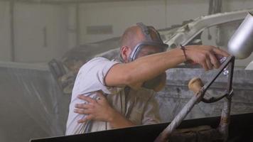 Process of car painting in workshop, worker in mask video