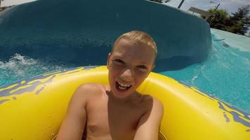 menino descendo um toboágua no parque aquático, vídeo pov