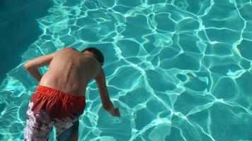 menino jogando água na piscina em câmera lenta, baleado no phantom flex 4k video