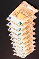 Diagonal line of euro notes isolated on black background, photo