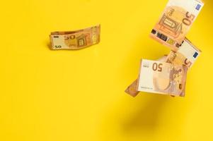 Rain of euro bills, flying falling money on a yellow background, photo