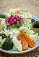 Ensalada rústica con una mezcla saludable de verduras frescas y al vapor en un plato colorido al aire libre en el jardín foto