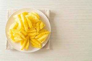 Fresh pineapple sliced on white plate photo