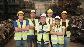 Varias etnias de ingenieros en uniformes y cascos en la fábrica. video