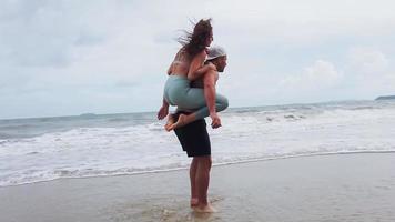 Pareja haciendo ejercicios por la mañana en la playa. video