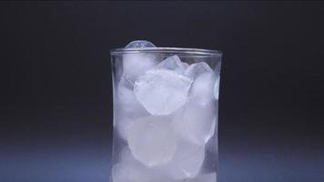 Time-lapse video, the ice in clear glass melting on black background. video