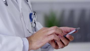 closeup de médico usando telefone celular video