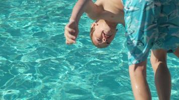 niño chapoteando en la piscina en cámara lenta, rodada en phantom flex 4k video