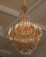 A large crystal chandelier hangs in the room. photo