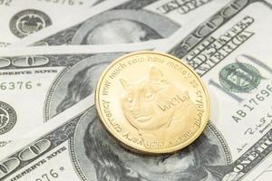 Dogecoin coin on dollar banknotes. Cryptocurrency on US dollar bills photo