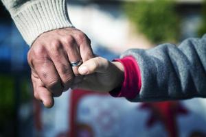 manos de padre e hijo abrazándose amor y cuidado foto