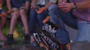 Familie braten Hot Dogs am Lagerfeuer
