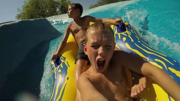 crianças descendo um toboágua no parque aquático, vídeo pov video