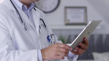 closeup de médico usando tablet digital video