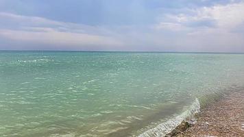 Seascape. Azure color of water, waves foaming on the shore. photo