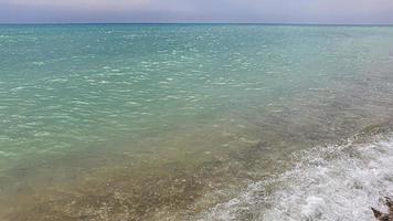 Seascape. Azure color of water, waves foaming on the shore. photo