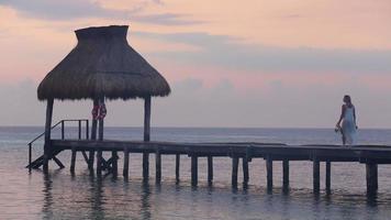 Mujer camina por el muelle en el resort tropical video