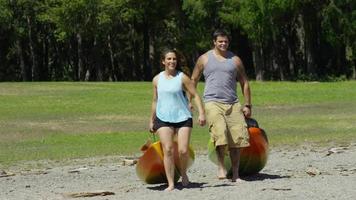 Couple carry kayaks to lake video