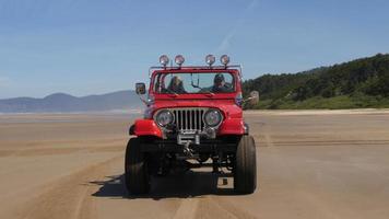 Couple driving 4x4 off road vehicle driving on beach video