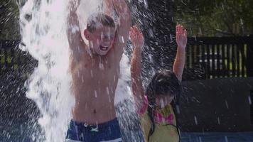 crianças brincando em fontes de água em dia de verão, câmera lenta
