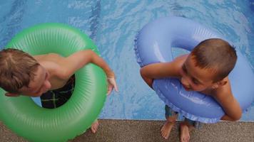 Two boys jump into pool, slow motion. video