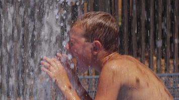 closeup de menino brincando em fontes de água em dia de verão, câmera lenta