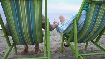 senior paar zittend op strandstoelen genieten van het uitzicht video