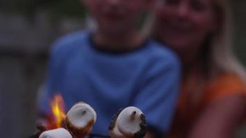 gros plan, faire griller des guimauves par un feu extérieur. video