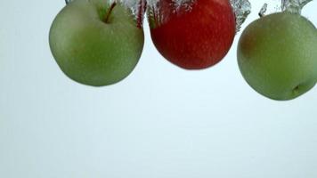 Apples splashing into water in slow motion video