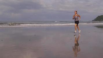 Woman running on beach, slow motion. video