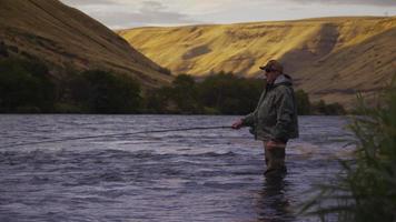 Hombre pescando con mosca en el hermoso río al amanecer. video