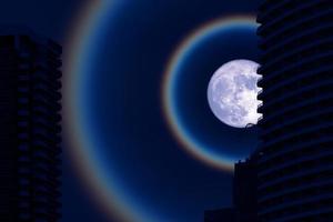 Superfruit blue moon halo with silhouette building on night sky photo