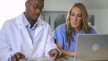 Doctor and nurse looking at x-ray in office video