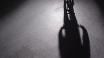 bmx-rijder doet trucs in een donker magazijn. video