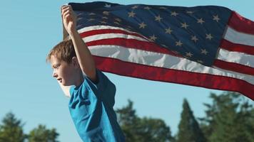 garçon qui court avec le drapeau américain, tourné sur un flex fantôme 4k video