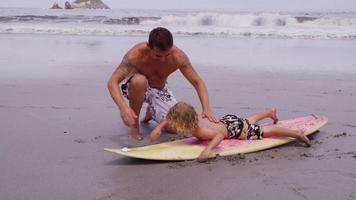 Vater bringt seinem Sohn das Surfen bei video