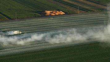 Aerial video of tractor applying lime to a grass field in Oregon