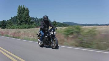 spårningsskott av mannen som kör motorcykel på landsväg. video