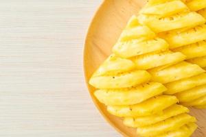 Fresh pineapple sliced on wooden plate photo