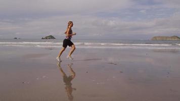 Woman running on beach, slow motion video