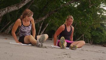 Frau, die sich für den Lauf am Strand ausdehnt und vorbereitet. video