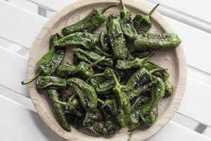 Pimientos Padrón español a la parrilla pimientos verdes tapas snack en la placa en el rústico restaurante de Santiago de Compostela foto