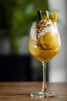 Organic mango and passion fruit tropical ice cream sundae in wine glass photo