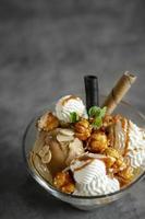 Caramel and almond ice cream with caramelized popcorn sundae dessert in glass bowl